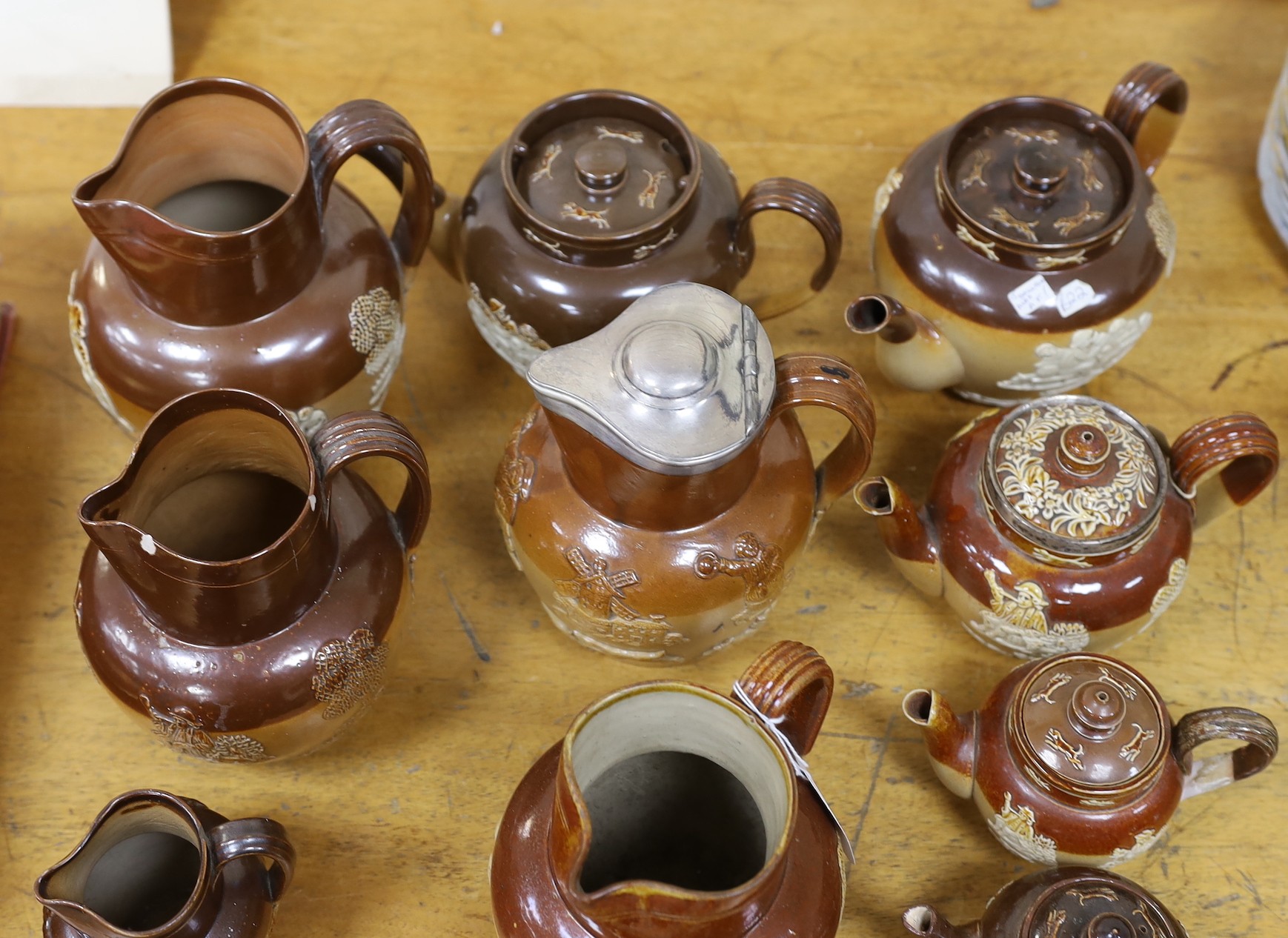 Eight various Royal Doulton Lambeth and other stoneware jugs and tea pots, one silver-mounted